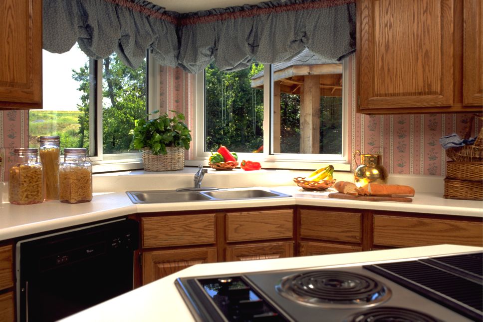Kitchen sink area with sliding windows overlooking a backyard